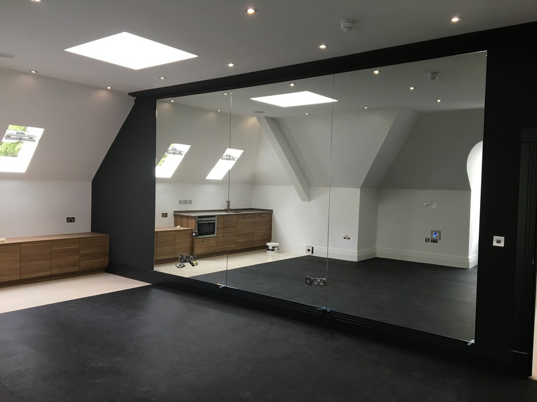 Frameless glass wall dividing loft conversion in Harpenden